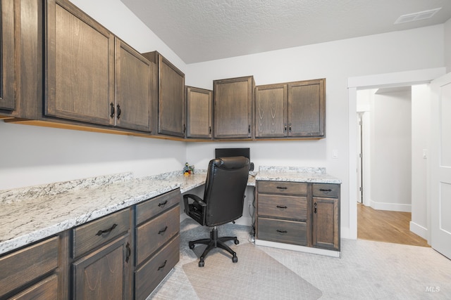 home office with visible vents, baseboards, built in desk, and a textured ceiling