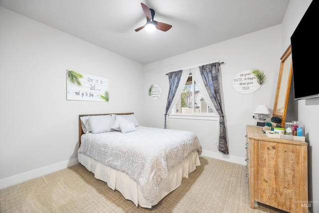 bedroom featuring a ceiling fan, baseboards, and light carpet