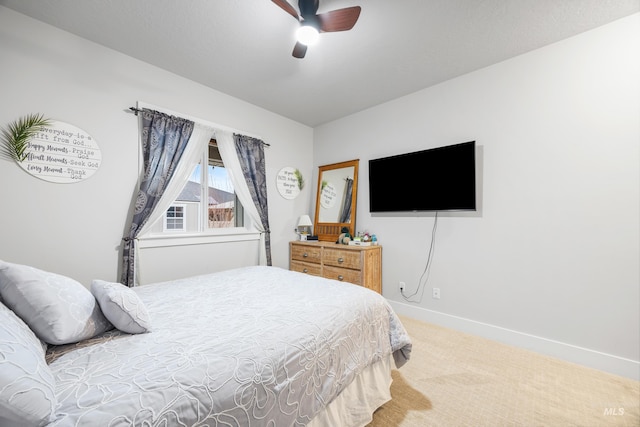 carpeted bedroom featuring baseboards and ceiling fan