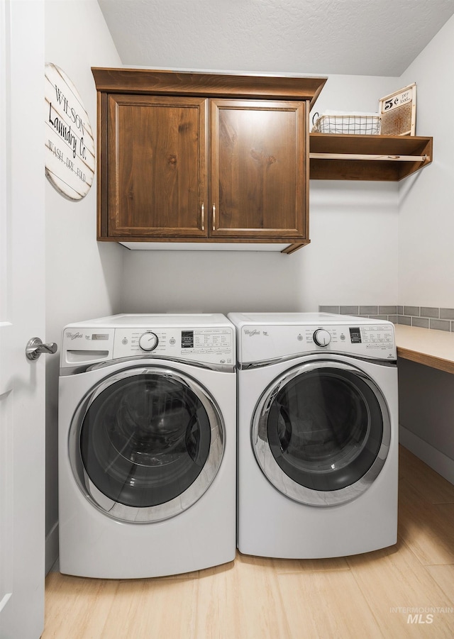 laundry area with cabinet space, light wood-style floors, and independent washer and dryer