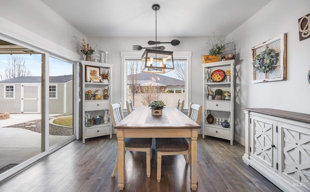 dining space featuring dark wood-type flooring and a chandelier