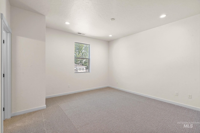 empty room with light carpet, baseboards, visible vents, and recessed lighting