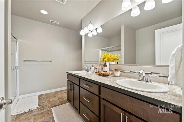 full bathroom featuring double vanity, a shower stall, visible vents, and a sink