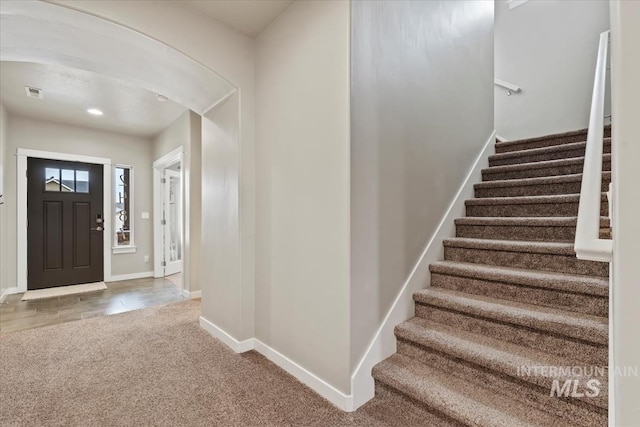 carpeted foyer featuring recessed lighting, visible vents, stairway, and baseboards