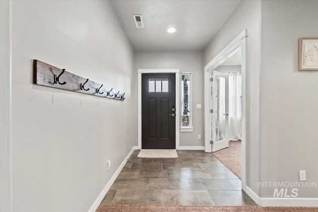 foyer with baseboards and visible vents