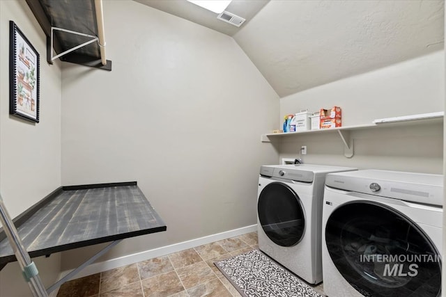 washroom featuring laundry area, visible vents, washer and clothes dryer, and baseboards