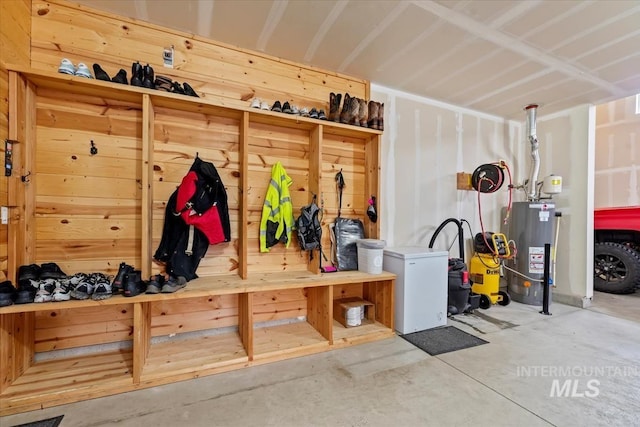 mudroom with gas water heater and unfinished concrete flooring