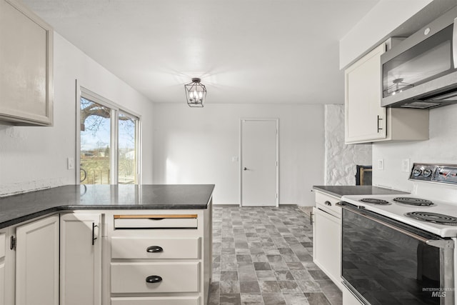 kitchen with white range with electric stovetop, white cabinetry, and an inviting chandelier