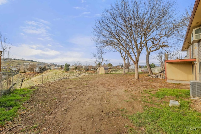 view of yard with central AC and a rural view