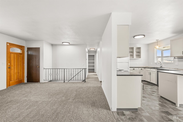 kitchen with white cabinets, carpet floors, white fridge, and hanging light fixtures