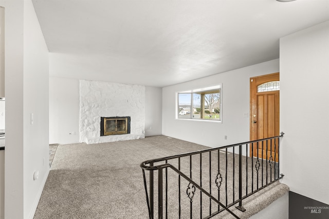 living room featuring a stone fireplace and carpet