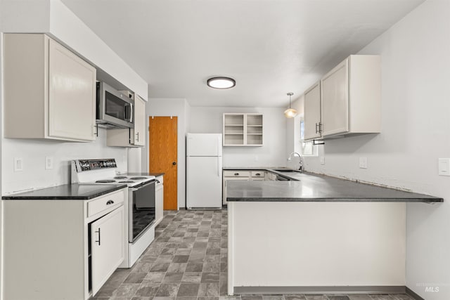 kitchen with kitchen peninsula, sink, decorative light fixtures, and white appliances