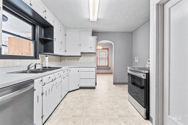 404 N Allumbaugh St, Boise, ID 83704 - kitchen with appliances with stainless steel finishes, a sink, arched walkways, light countertops, and white cabinets