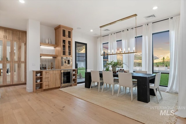 6162 N High Valley Way, Boise, ID 83714 - dining area with beverage cooler, light wood-type flooring, recessed lighting, and bar area