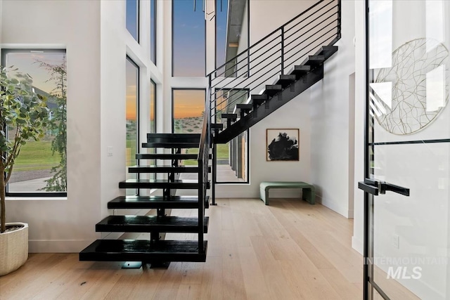 6162 N High Valley Way, Boise, ID 83714 - stairway featuring a towering ceiling, wood finished floors, healthy amount of natural light, and baseboards