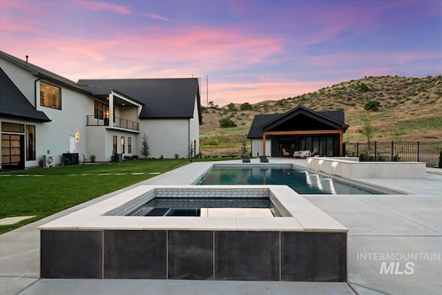 6162 N High Valley Way, Boise, ID 83714 - pool at dusk featuring a patio, a mountain view, a pool with connected hot tub, and central air condition unit