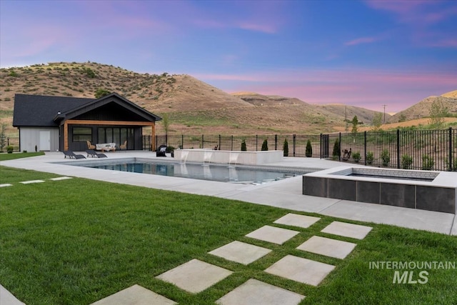6162 N High Valley Way, Boise, ID 83714 - pool at dusk featuring a mountain view, an outdoor hot tub, and a patio area
