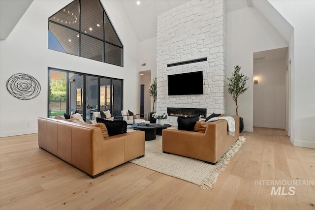 6162 N High Valley Way, Boise, ID 83714 - living room with high vaulted ceiling, baseboards, wood finished floors, and a stone fireplace
