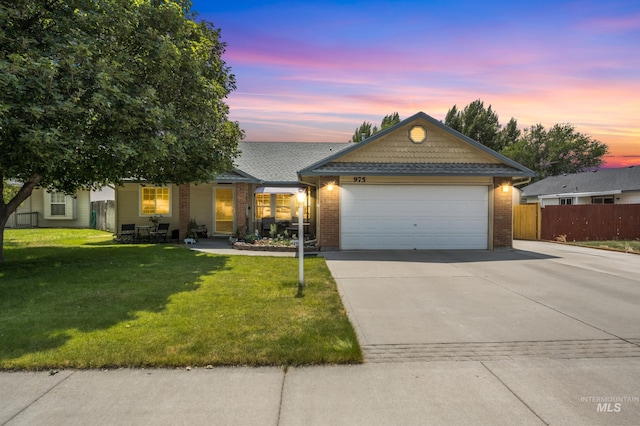 single story home with a garage and a yard