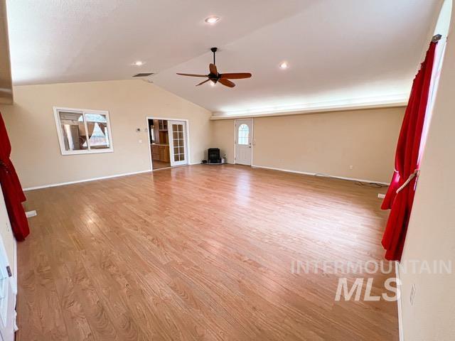 bedroom with a spacious closet, ceiling fan, light colored carpet, ensuite bathroom, and a closet