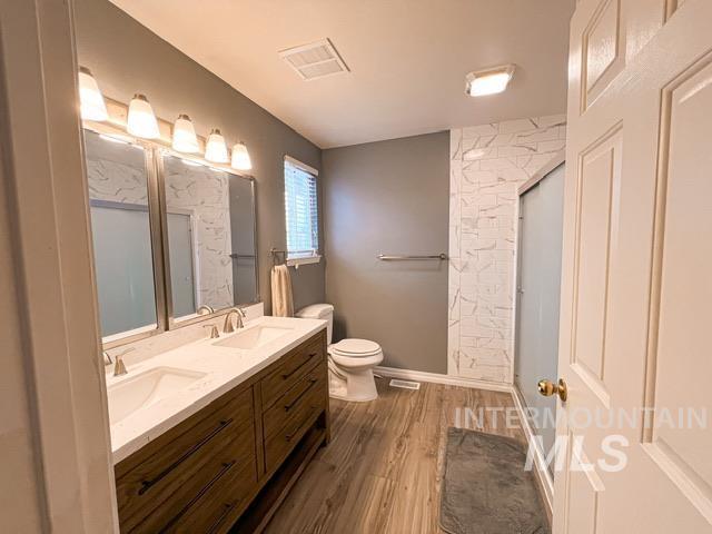 bathroom featuring toilet, hardwood / wood-style floors, and an enclosed shower