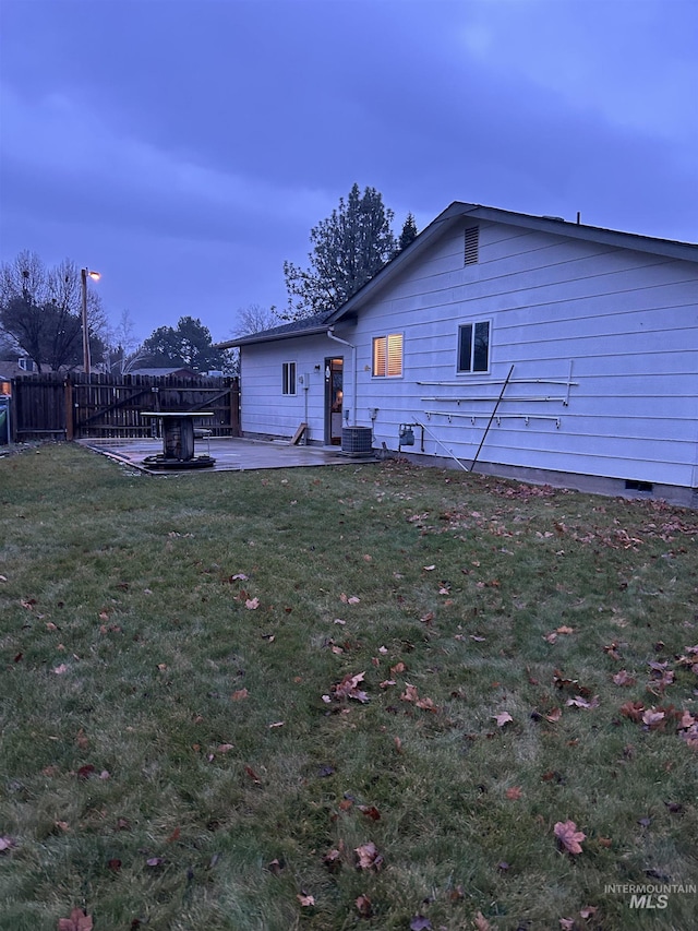 back of house featuring a lawn, a patio, and central AC unit