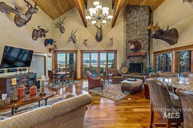 516 Whitewater Dr, Donnelly, ID 83615 - living room with high vaulted ceiling, wooden ceiling, a stone fireplace, and a notable chandelier