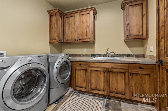 516 Whitewater Dr, Donnelly, ID 83615 - laundry area featuring washer and clothes dryer, cabinets, sink, and light tile floors
