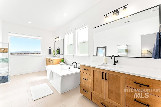 3012 E Parulo Dr, Meridian, ID 83642 - bathroom with two vanities, visible vents, a freestanding tub, and a sink