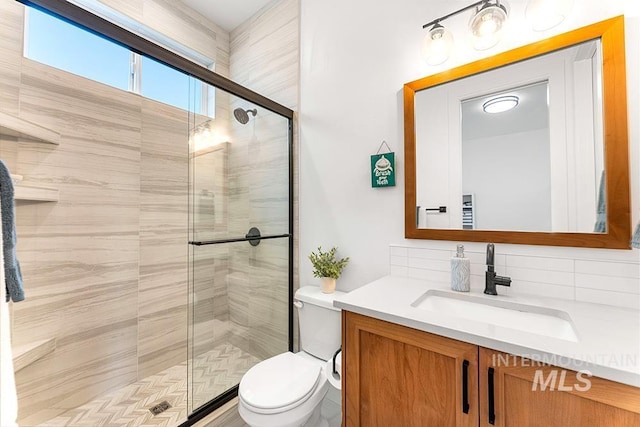 3012 E Parulo Dr, Meridian, ID 83642 - bathroom featuring a shower stall, decorative backsplash, toilet, and vanity