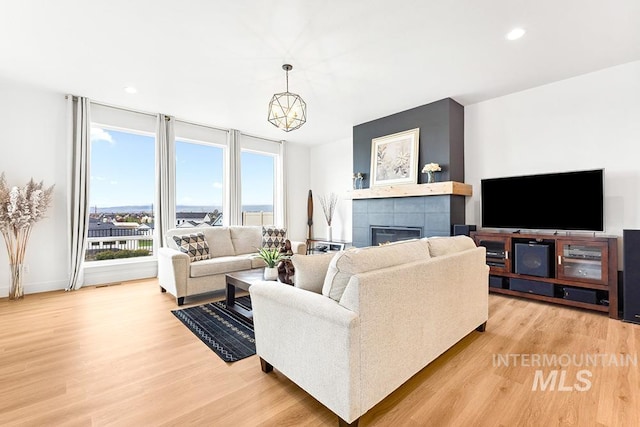 3012 E Parulo Dr, Meridian, ID 83642 - living area with light wood-style flooring, a tile fireplace, and plenty of natural light