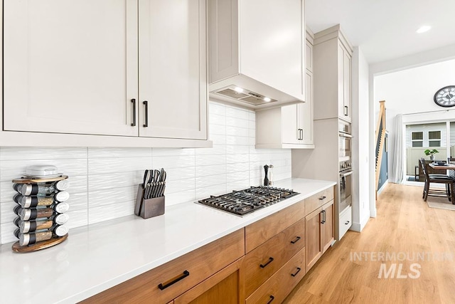 3012 E Parulo Dr, Meridian, ID 83642 - kitchen with light countertops, light wood-style floors, decorative backsplash, appliances with stainless steel finishes, and custom exhaust hood