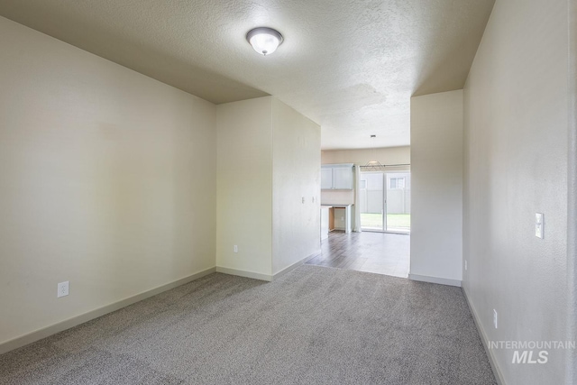 11965 Goldfinch St, Caldwell, ID 83605 - carpeted empty room with baseboards and a textured ceiling