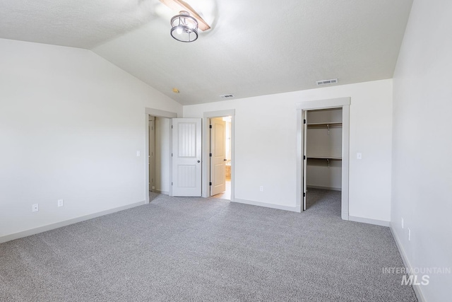 11965 Goldfinch St, Caldwell, ID 83605 - unfurnished bedroom with vaulted ceiling, baseboards, carpet floors, a spacious closet, and connected bathroom