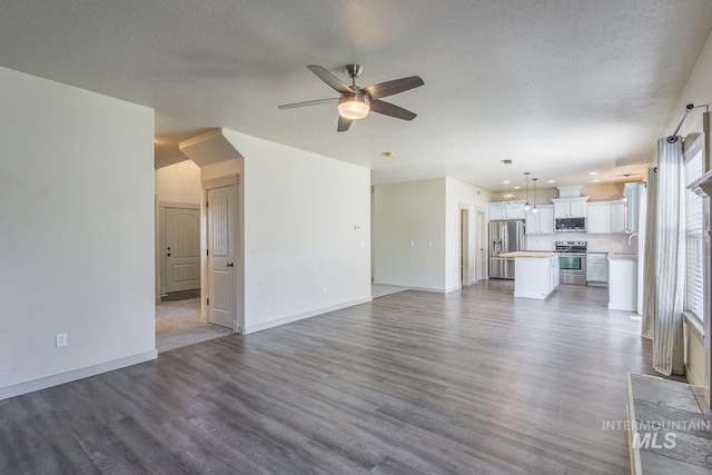 11965 Goldfinch St, Caldwell, ID 83605 - unfurnished living room with a ceiling fan, dark wood-style floors, a sink, baseboards, and a textured ceiling