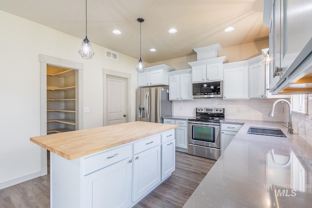 11965 Goldfinch St, Caldwell, ID 83605 - kitchen featuring stainless steel appliances, a sink, wood counters, dark wood finished floors, and decorative backsplash