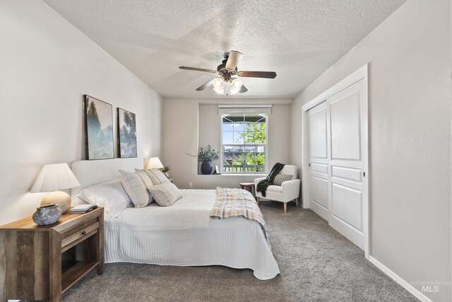 bedroom featuring carpet floors, a textured ceiling, and ceiling fan