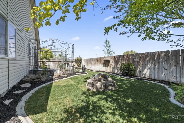 view of yard featuring a fire pit and a fenced backyard
