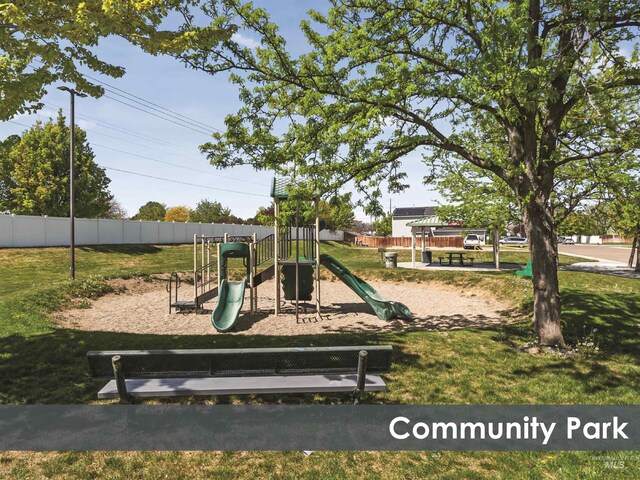 communal playground featuring fence and a lawn