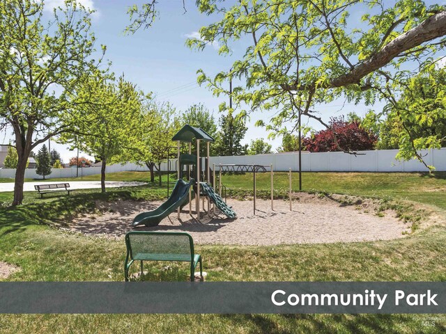 community jungle gym with a yard and fence