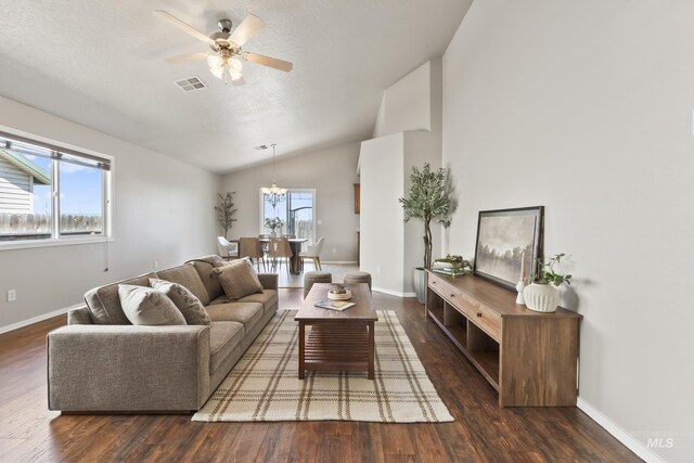 living room with visible vents, wood finished floors, lofted ceiling, and ceiling fan with notable chandelier