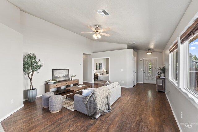 living room with a ceiling fan, visible vents, wood finished floors, baseboards, and lofted ceiling
