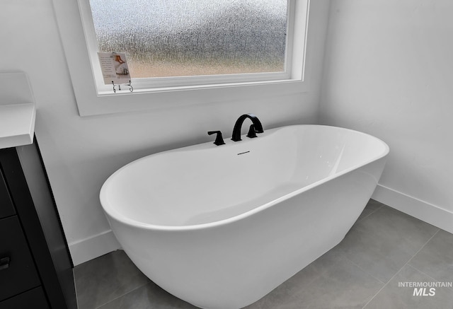 bathroom featuring tile patterned floors and a tub to relax in