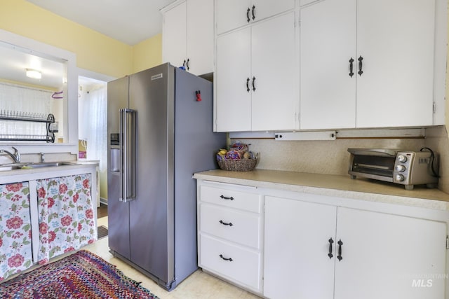 411 E 6th Ave, Twin Falls, ID 83301 - kitchen featuring high end fridge, a sink, light countertops, white cabinetry, and backsplash