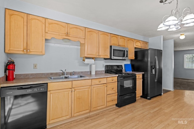 7171 Bluebird, Boise, ID 83703 - kitchen featuring black appliances, a chandelier, light brown cabinetry, light wood-style floors, and light countertops