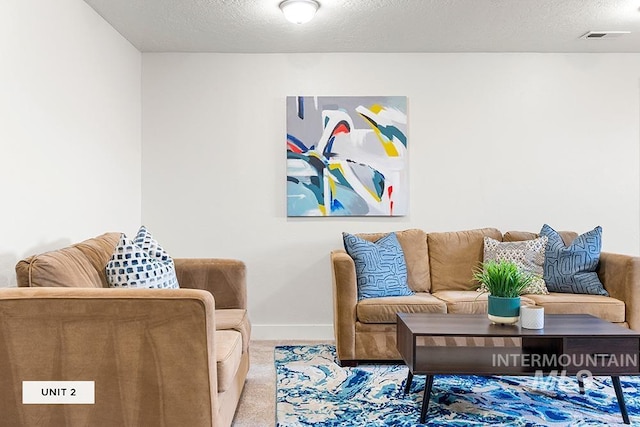 living room with light carpet and a textured ceiling