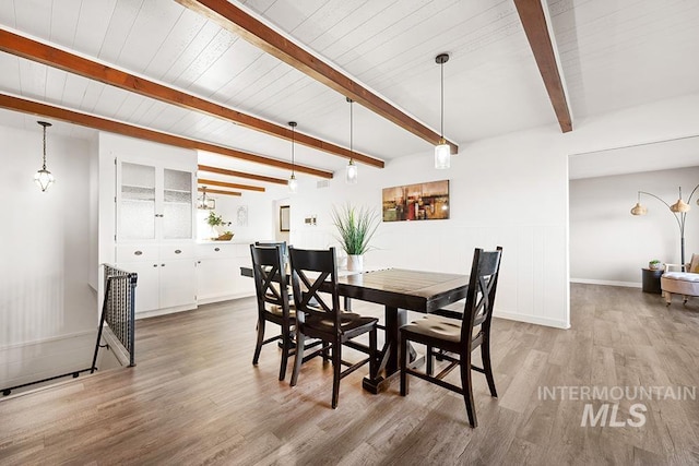 dining area featuring wood ceiling, beamed ceiling, and light wood-type flooring