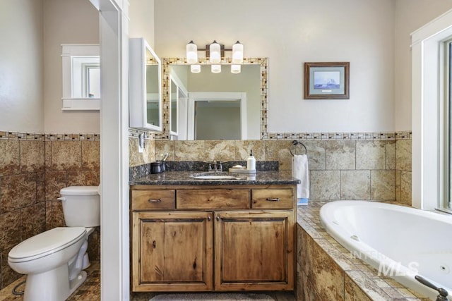 2157 Cayuse St, Twin Falls, ID 83301 - full bathroom featuring tile walls, toilet, a whirlpool tub, vanity, and wainscoting