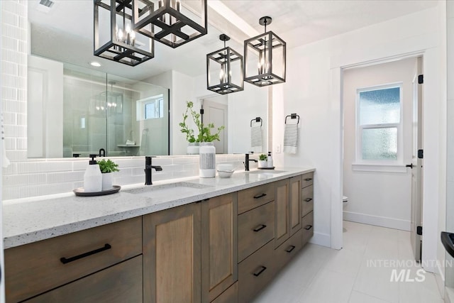 bathroom with tile patterned flooring, vanity, backsplash, and a shower with shower door