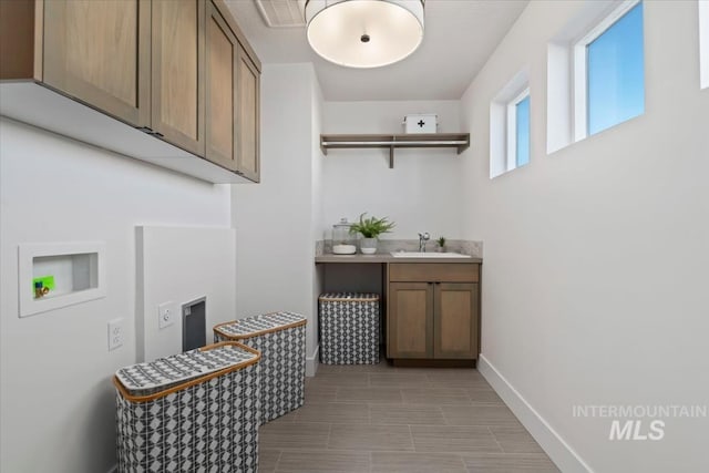 clothes washing area featuring cabinets, hookup for a washing machine, and sink